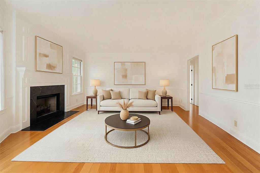A living room with a fireplace, white sofa, round coffee table, and hardwood floors — 6581 S MAGNOLIA AVENUE, OCALA, FL