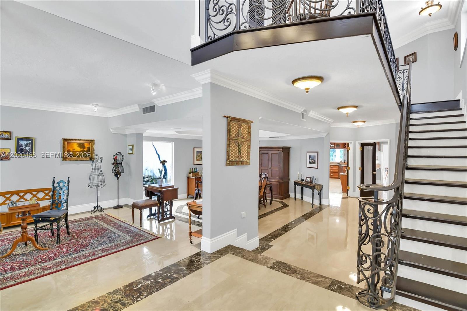 A grand foyer features a sweeping staircase with wrought iron railings and marble flooring — 3401 SW 129th Ave, Miami FL 33175, MIAMI, FL