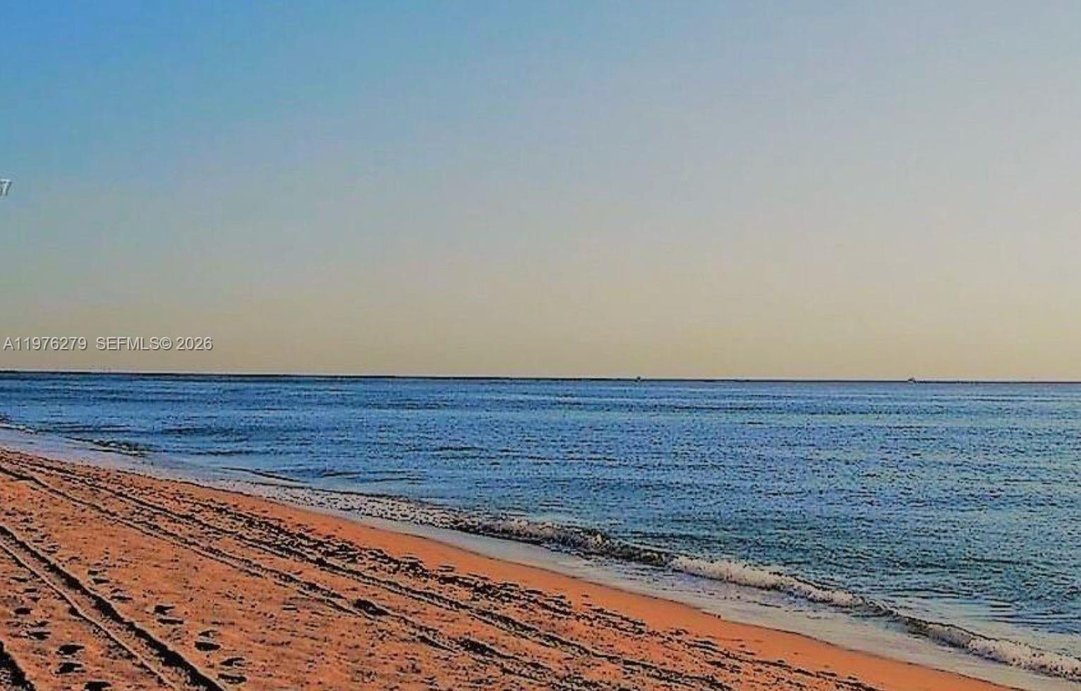 A view of a sandy beach meeting the ocean under a clear sky — 4111 S Ocean Dr # 3704, Hollywood FL 33019, HOLLYWOOD, FL