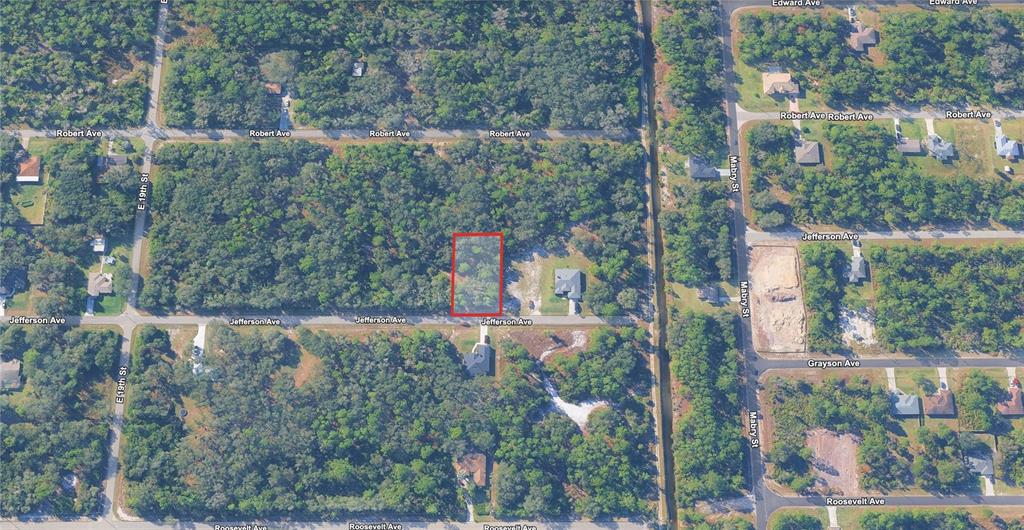 An aerial view shows a rectangular vacant lot outlined in red along a residential street — 1915 JEFFERSON AVENUE, LEHIGH ACRES, FL