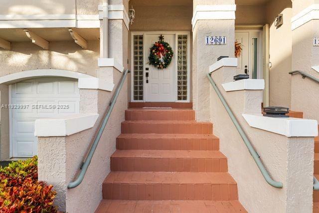 A set of brick stairs leads to a front door decorated with a holiday wreath — 12691 NW 14th Pl, Sunrise FL 33323, SUNRISE, FL
