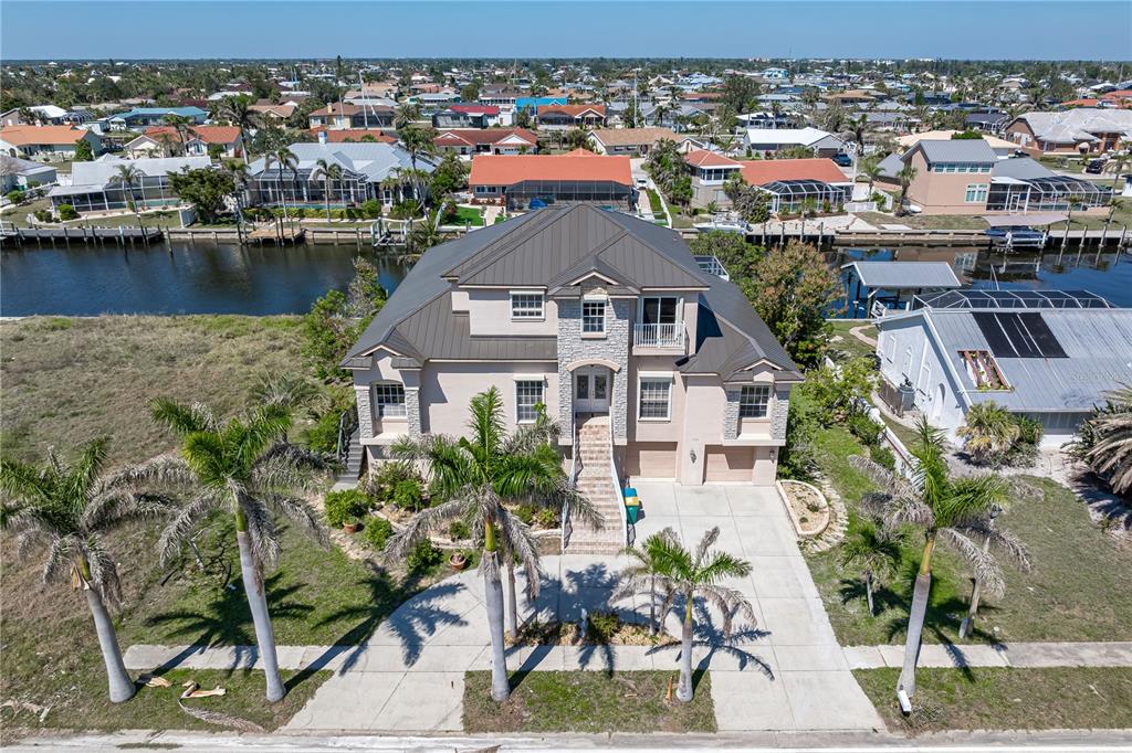 An aerial view of a two-story house with a metal roof and palm trees — 250 GEORGE ROAD, PORT CHARLOTTE, FL