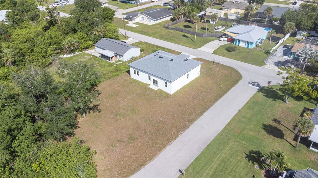 An aerial view shows a white house with a gray roof on a large lot — 543 CHAMBER STREET NW, PORT CHARLOTTE, FL