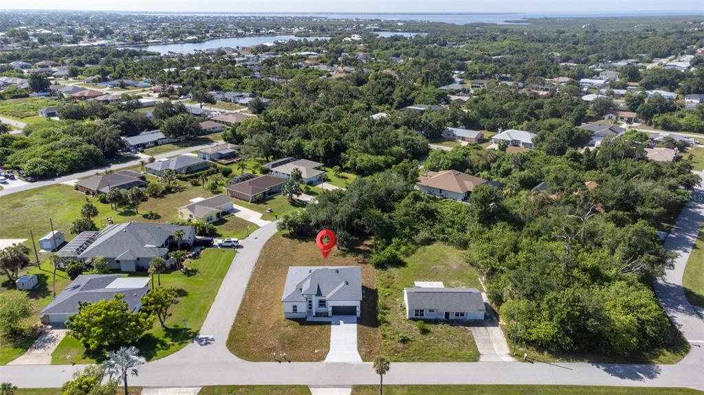 An aerial view shows a modern house with a red location pin on a lot — 543 CHAMBER STREET NW, PORT CHARLOTTE, FL