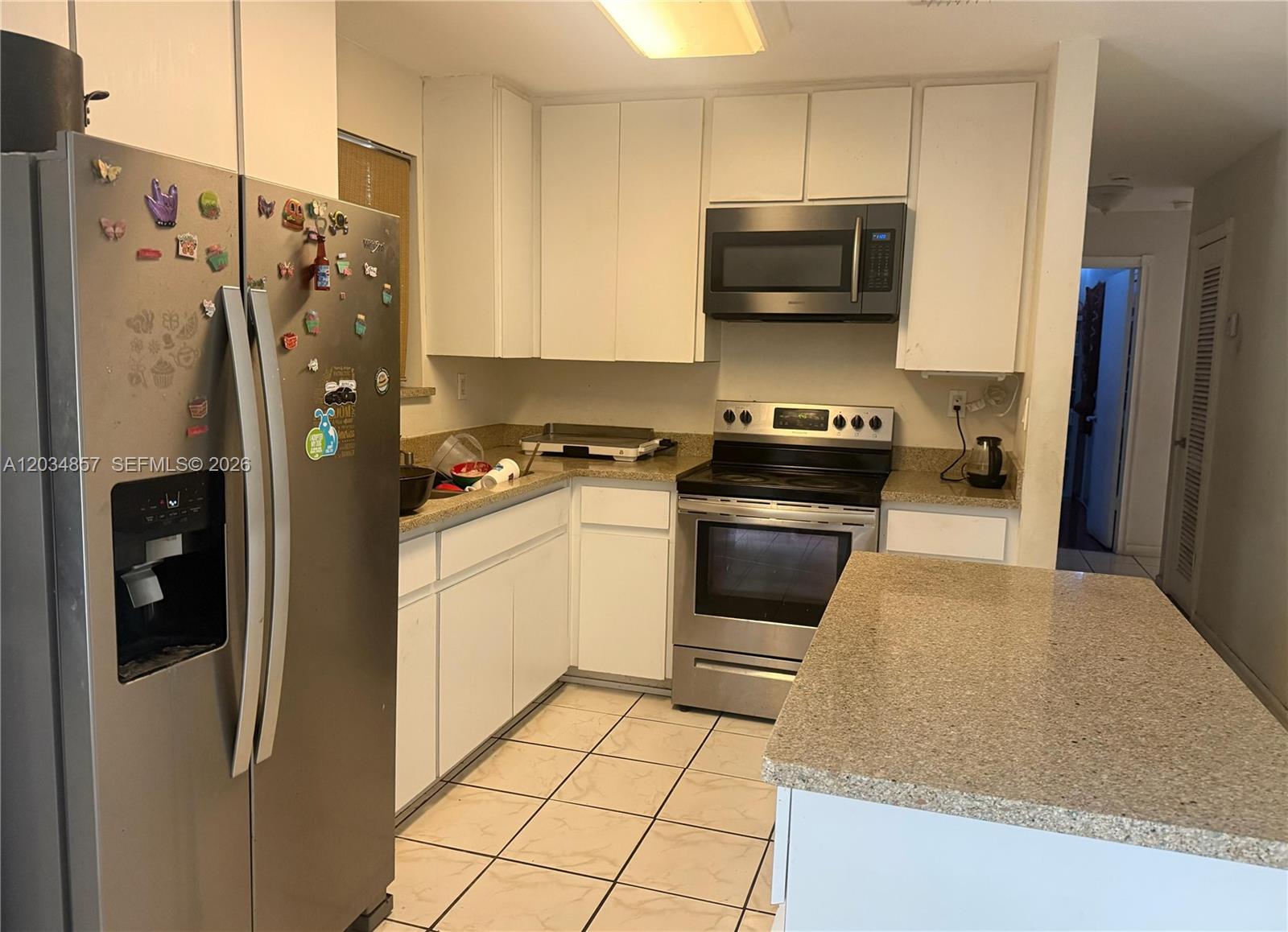 A kitchen features white cabinets, stainless steel appliances, a center island, and tiled flooring — 767 SW 5th Ter, Florida City FL 33034, FLORIDA CITY, FL