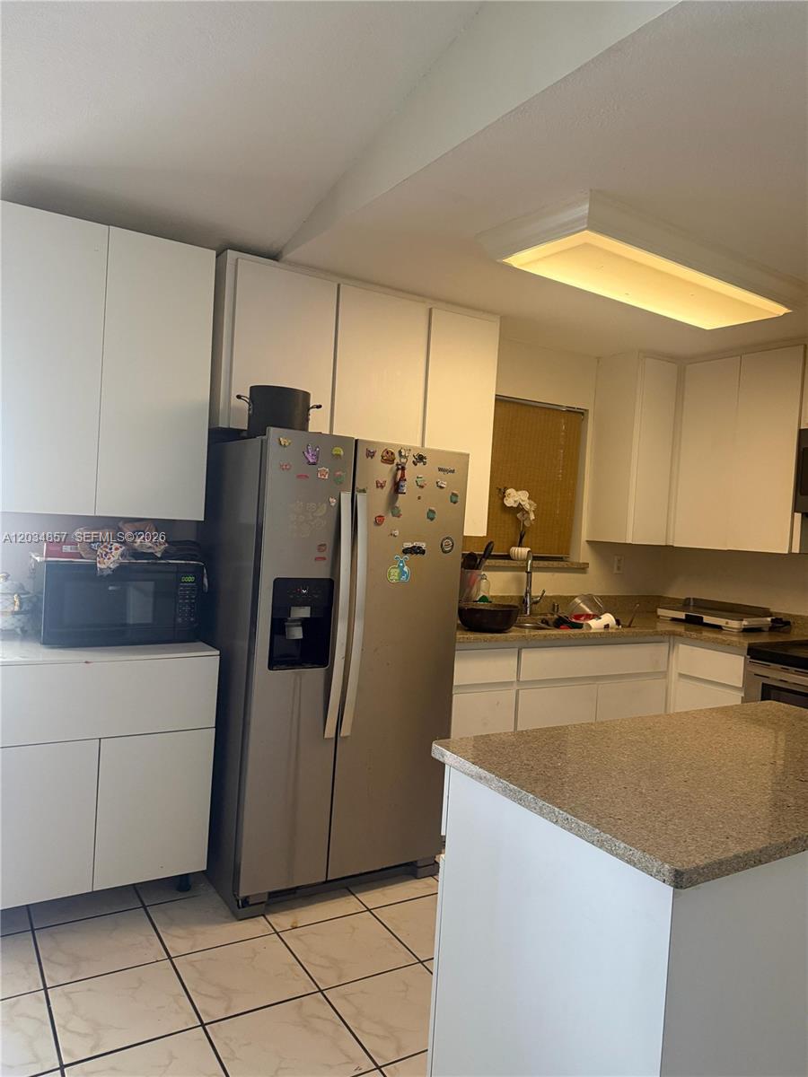 A white microwave with an open door sits on a shelf above a wall outlet — 767 SW 5th Ter, Florida City FL 33034, FLORIDA CITY, FL
