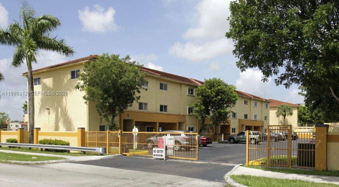 A three-story apartment building with a gated parking lot and palm trees — 8270 SW 149th Ct # 209, Miami FL 33193, MIAMI, FL