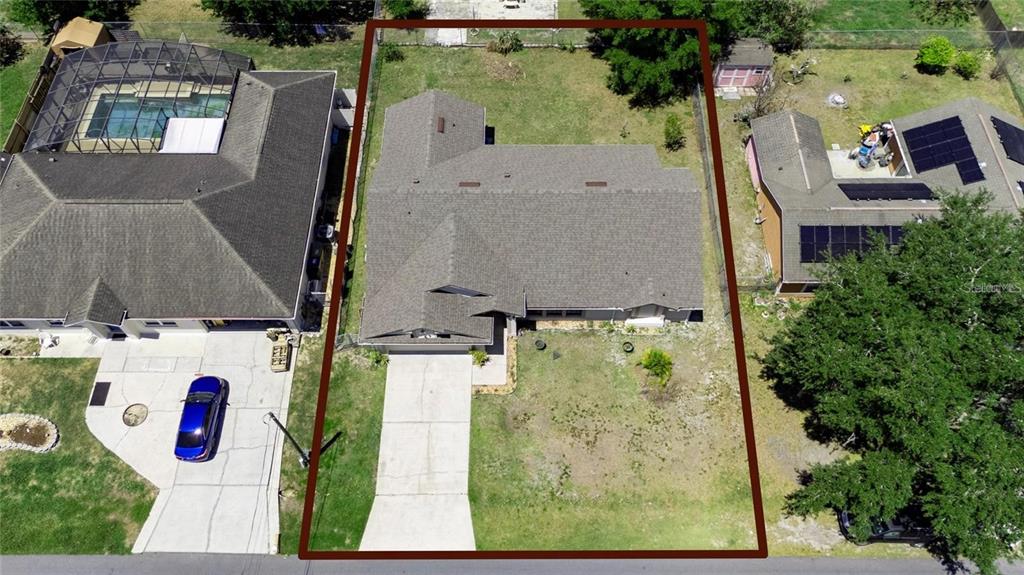 An aerial view shows a single-story house with a gray roof and a concrete driveway — 307 COLONY COURT, KISSIMMEE, FL
