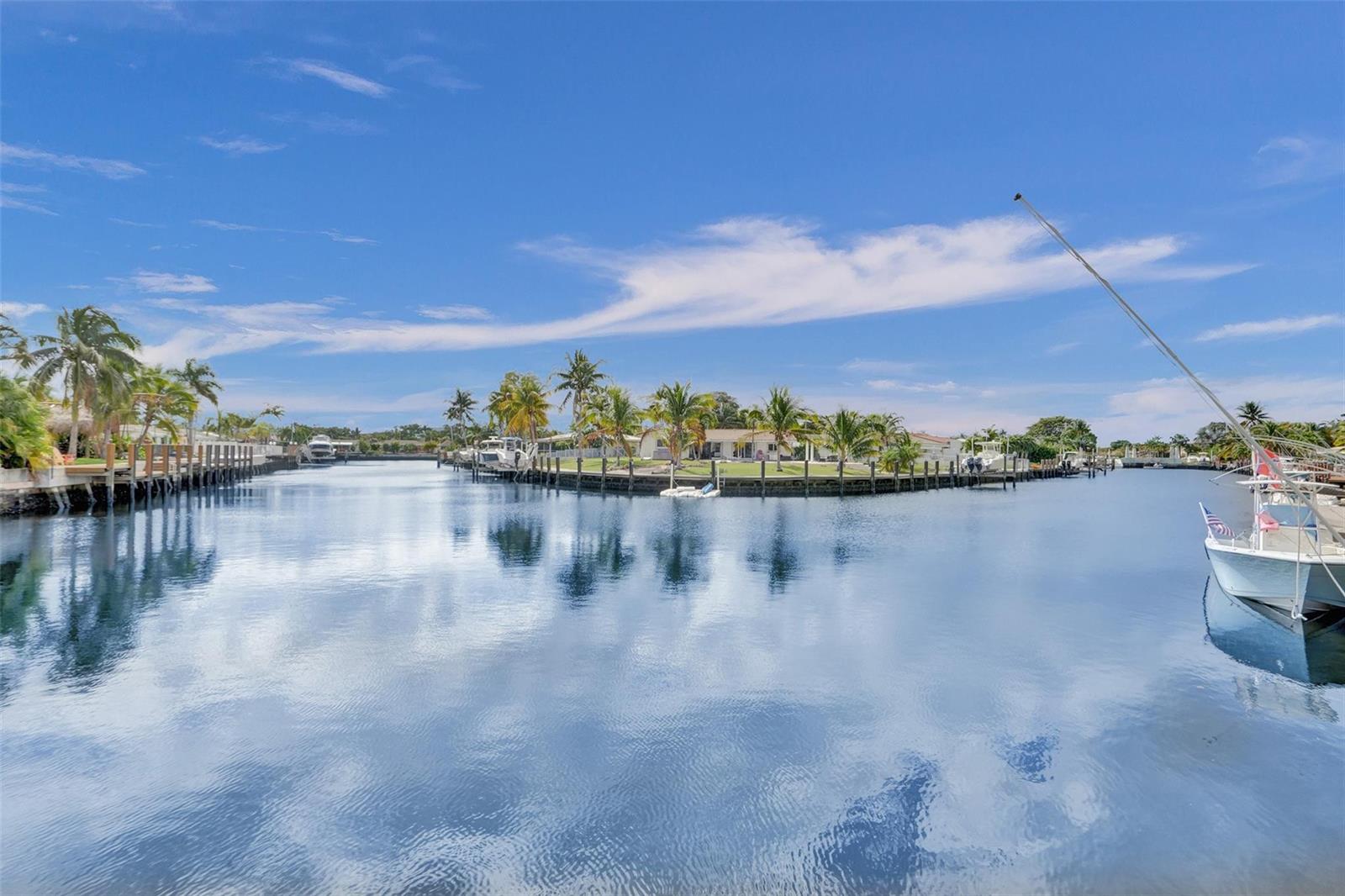 A view of a calm canal lined with palm trees, docks, and several moored boats — 935 SE 9th Avenue # 16, Pompano Beach FL 33060, POMPANO BEACH, FL