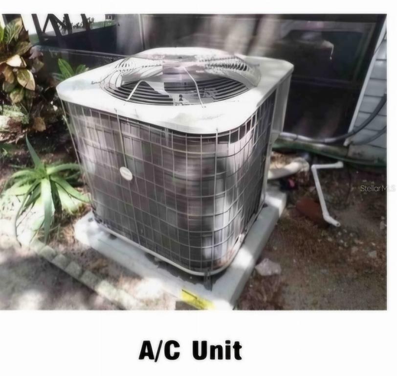 An outdoor air conditioning condenser unit sits on a concrete pad next to a house — 619 HEATHERTON VILLAGE, ALTAMONTE SPRINGS, FL