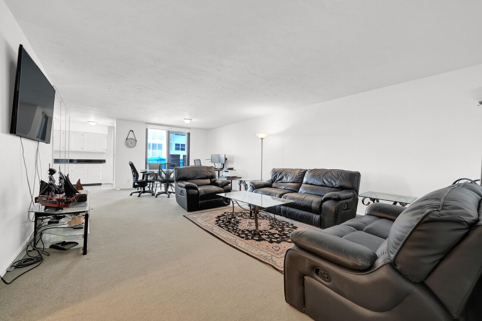 A living room features black leather furniture, a glass coffee table, and a patterned rug — 1000 S Ocean Boulevard # o, Pompano Beach FL 33062, POMPANO BEACH, FL