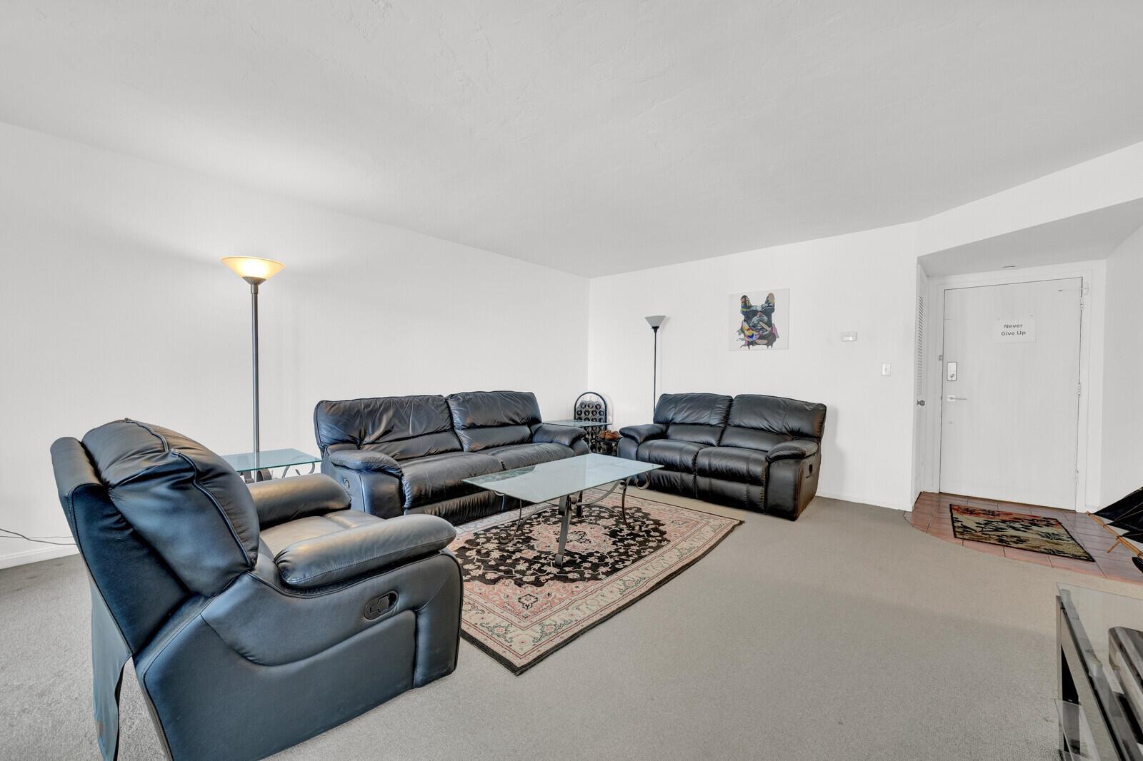 A living room features black leather furniture, a glass coffee table, and a patterned area rug — 1000 S Ocean Boulevard # o, Pompano Beach FL 33062, POMPANO BEACH, FL