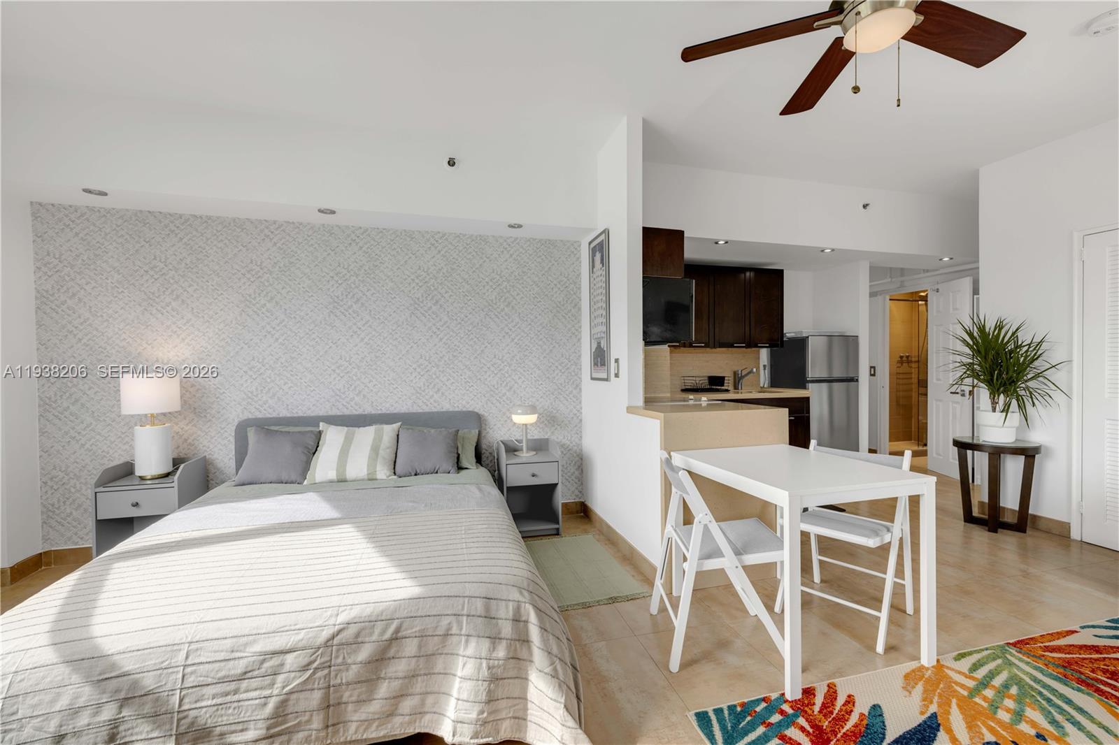 A studio apartment features a bed, a small dining table, and an open kitchen area — 255 W 24th St # 542, Miami Beach FL 33140, MIAMI BEACH, FL