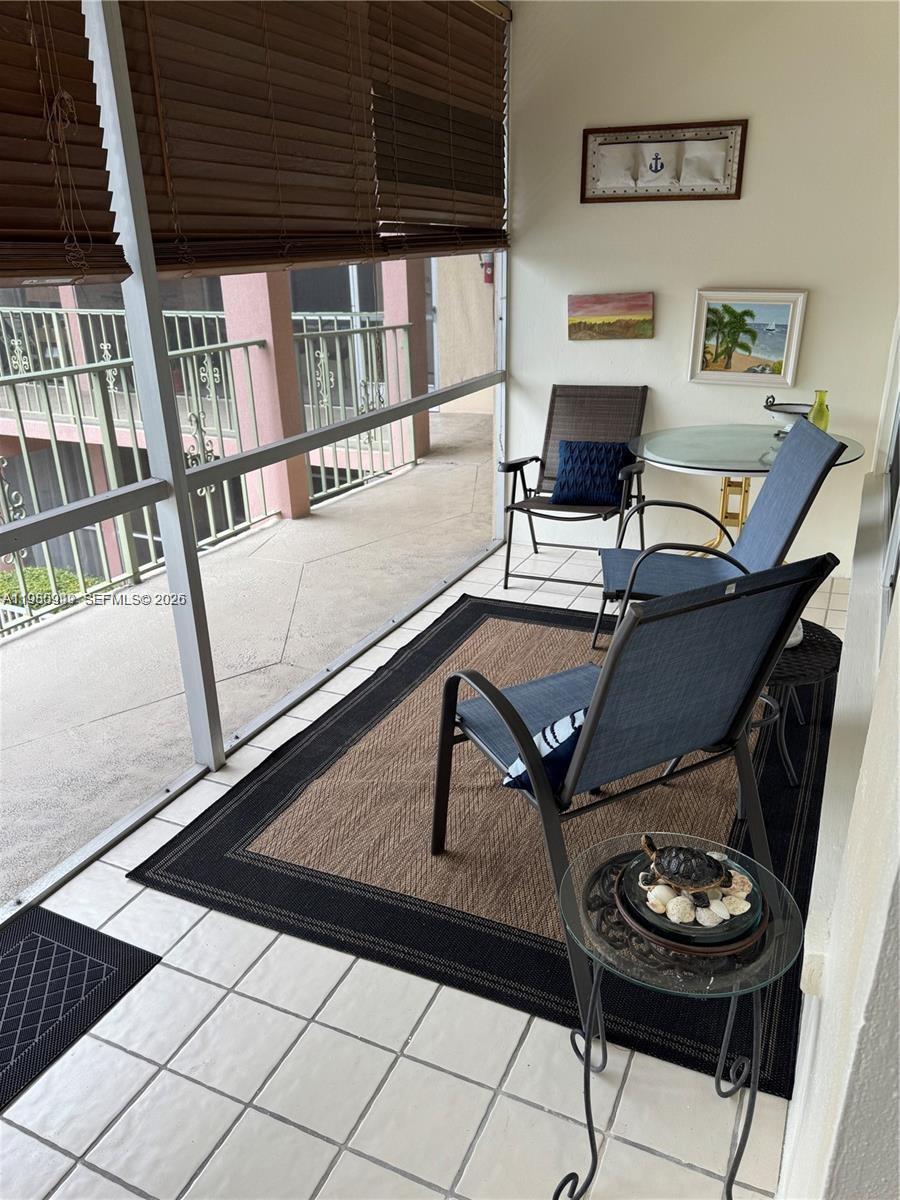 A kitchen features beige cabinets, marble-look countertops, a stainless steel stove, and decorative metal backsplash — 100 SE 6th Ave # 207, Pompano Beach FL 33060, POMPANO BEACH, FL