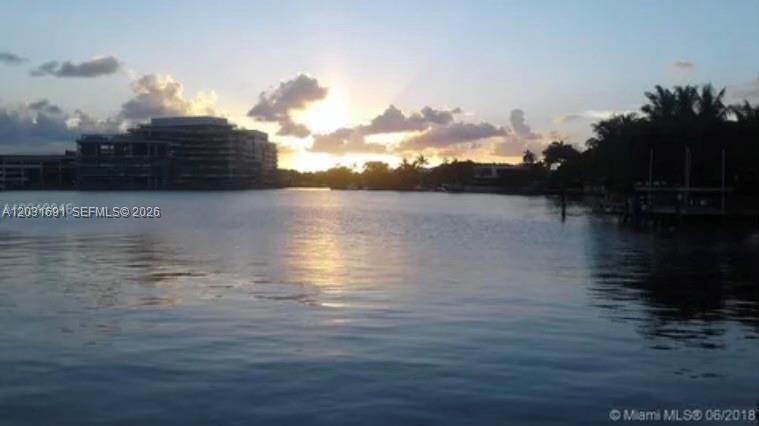 A sunset view over a body of water with a large building on the horizon — 4740 Pine Tree Dr # 25, Miami Beach FL 33140, MIAMI BEACH, FL