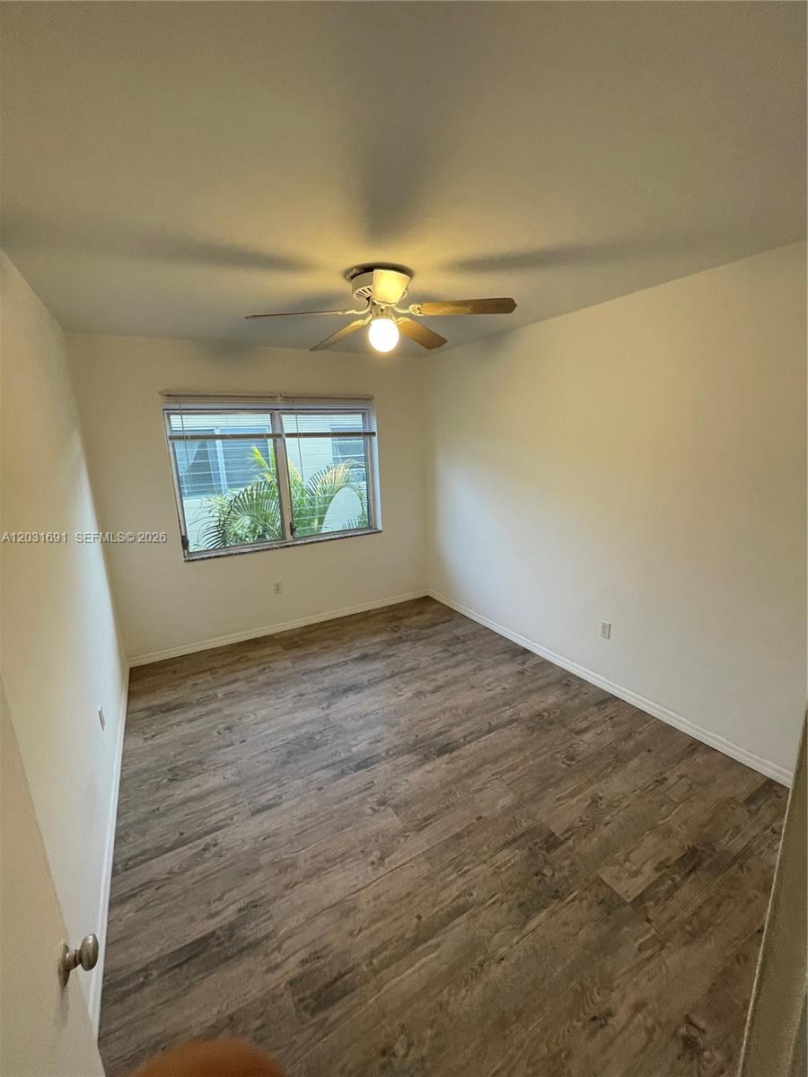 An empty bedroom features light-colored walls, wood-look flooring, and a ceiling fan — 4740 Pine Tree Dr # 25, Miami Beach FL 33140, MIAMI BEACH, FL