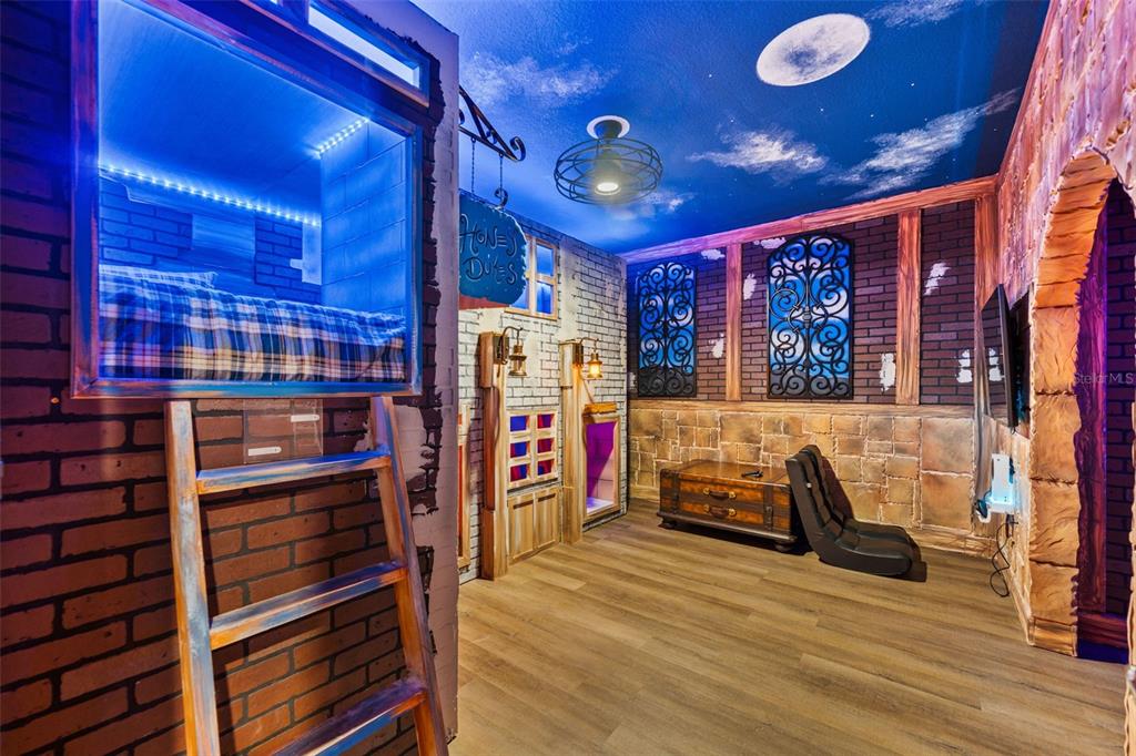 A themed bedroom features a loft bed, brick-style walls, and a painted night sky ceiling — 1187 KINGSBARN STREET, DAVENPORT, FL