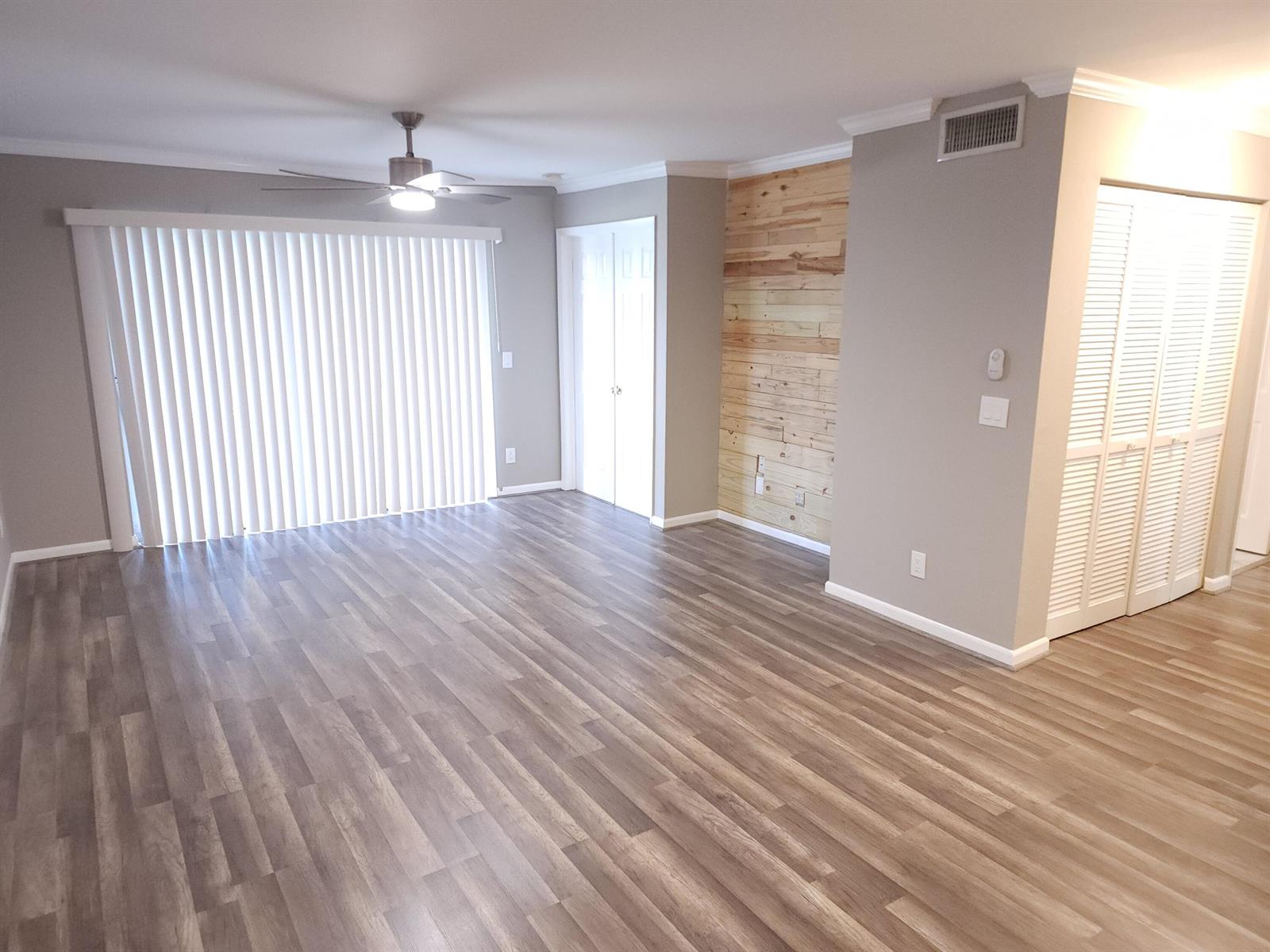 A view from inside through a sliding glass door onto a tiled patio and lawn — 1740 Palm Cove Boulevard # 103, Delray Beach FL 33445, DELRAY BEACH, FL