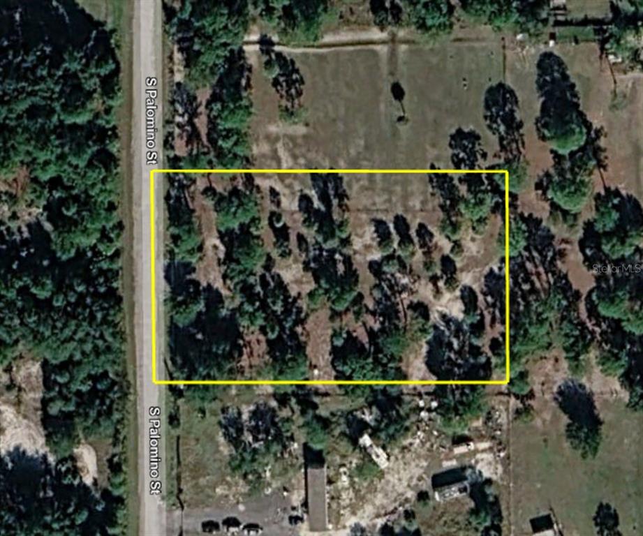 An aerial view shows a rectangular plot of land outlined in yellow along a road — 345 S PALOMINO STREET, CLEWISTON, FL