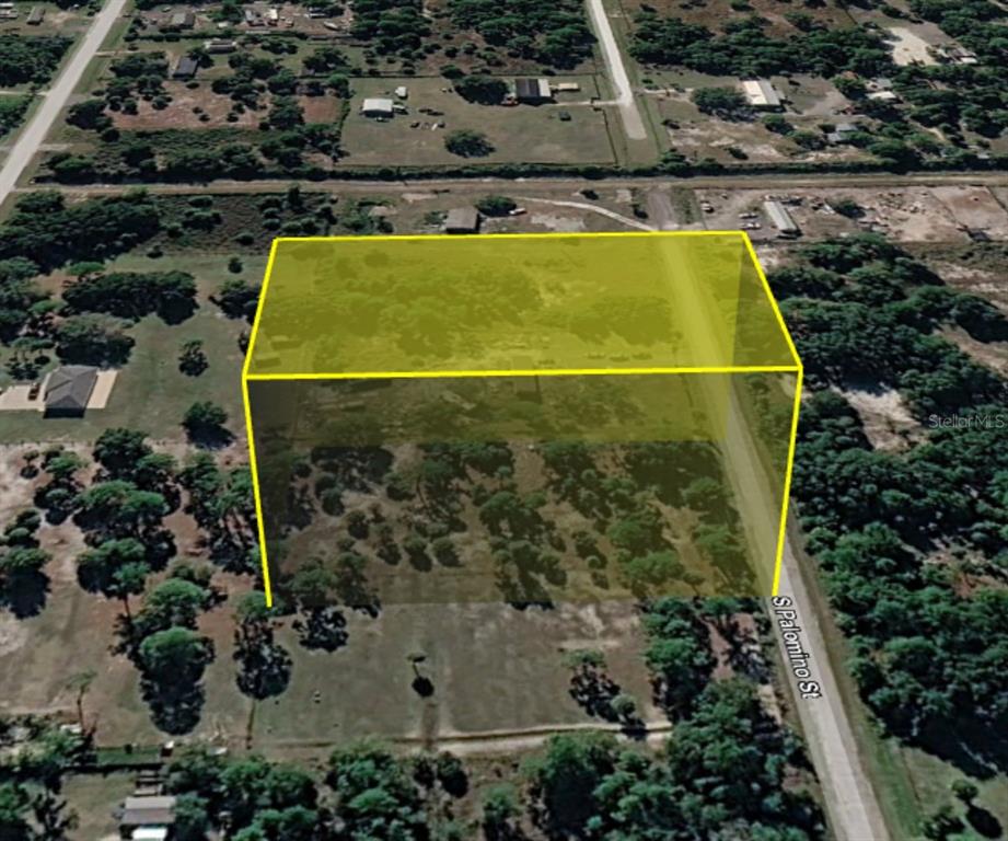 An aerial view shows a vacant, wooded lot highlighted by a yellow digital boundary overlay — 345 S PALOMINO STREET, CLEWISTON, FL