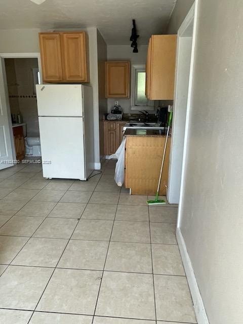 A kitchen features light wood cabinets, a white refrigerator, and beige tile flooring — 2121 LAKEVIEW DRIVE, Sebring FL 33870, SEBRING, FL