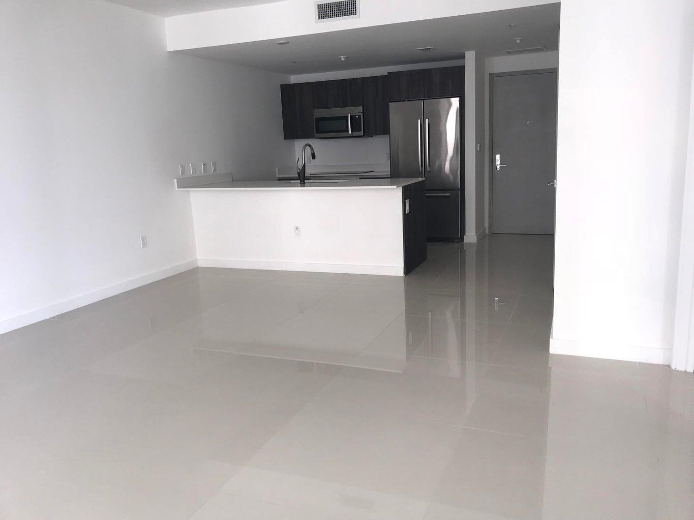 An open-concept kitchen with dark cabinets, stainless steel appliances, and a white breakfast bar — 488 NE 18th Street # 807, Miami FL 33132, MIAMI, FL