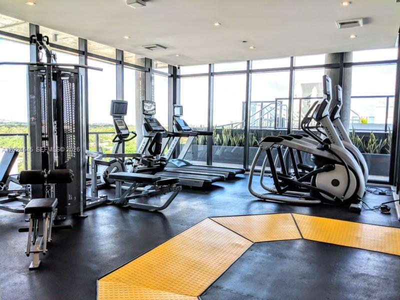A gym with exercise equipment, large windows, and a yellow rubber floor mat — 201 SW 17th Rd # 304, Miami FL 33129, MIAMI, FL