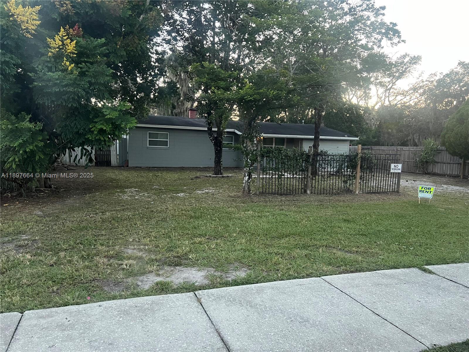 A single-story gray house sits behind a black metal fence with a for rent sign — 6632 Edgewater Drive # 0, Orlando FL 32810, ORLANDO, FL
