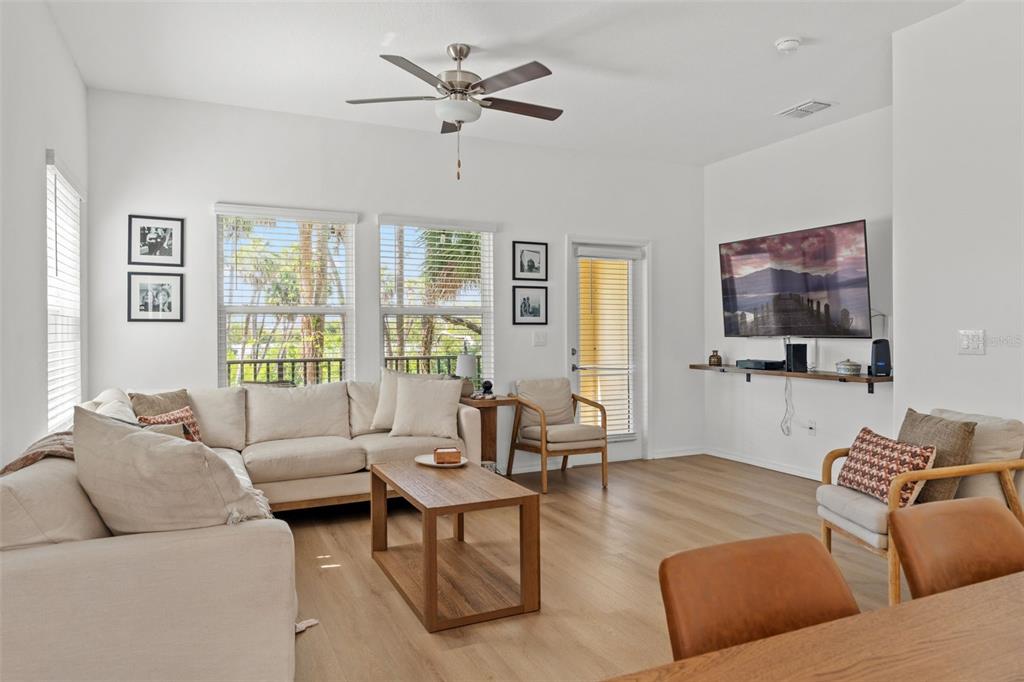 A bright living room features a beige sectional sofa, a wooden coffee table, and a television — 4720 TUSCAN LOON DRIVE, TAMPA, FL