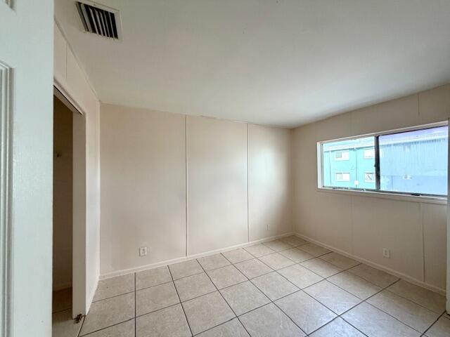 An empty bedroom features beige walls, light-colored tile flooring, and a single window — 1829 N A Street # 66, FL 33460, FL