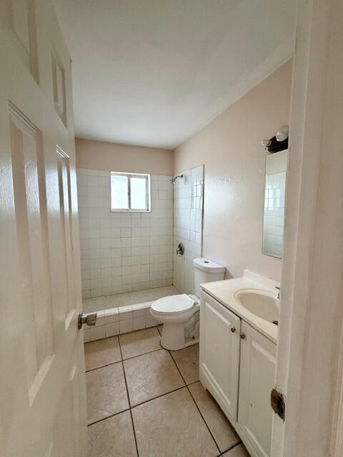 A bathroom features a white vanity, a toilet, and a tiled shower stall with a window — 1829 N A Street # 66, FL 33460, FL