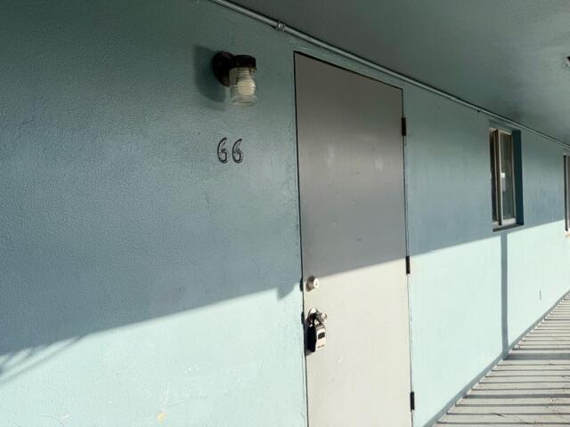 A light blue exterior wall features a door labeled 66 with a mounted light fixture — 1829 N A Street # 66, FL 33460, FL