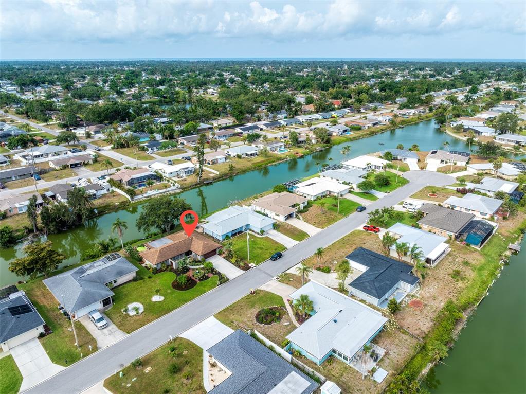 An aerial view shows a residential neighborhood with houses situated along a canal — 2360 BAL HARBOUR DRIVE, VENICE, FL