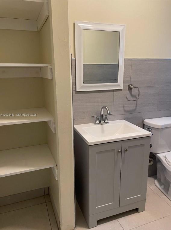 A bathroom features a gray vanity, a white sink, a mirror, and built-in shelving — 1720 Pierce St # 3, Hollywood FL 33020, HOLLYWOOD, FL