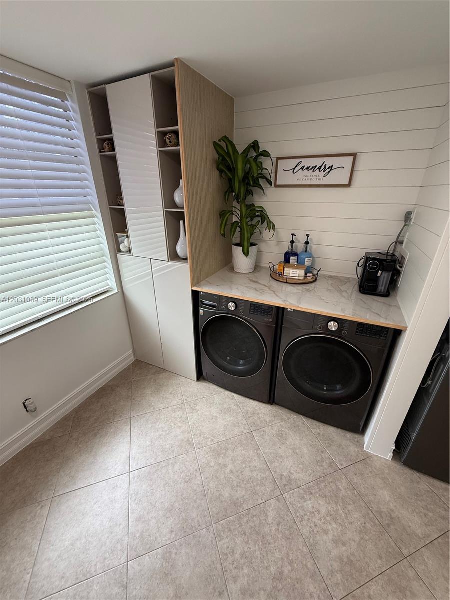 A laundry room features dark appliances, a marble-look countertop, and white shiplap walls — 1020 NW 80th Ave # 104, Margate FL 33063, MARGATE, FL