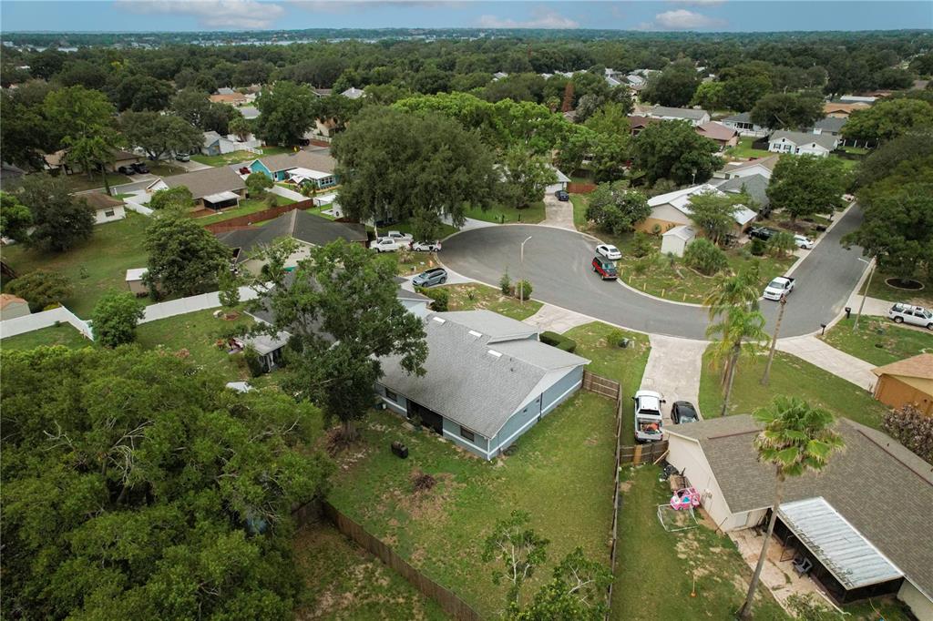 An aerial view shows a suburban neighborhood with houses, driveways, and mature trees — 358 N FORK PLACE, LAKELAND, FL