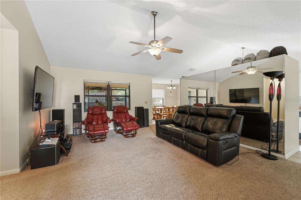 A living room features a black sofa, two red recliners, and a large mirrored wall — 358 N FORK PLACE, LAKELAND, FL