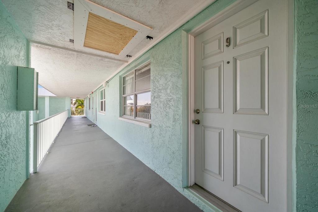 A white door labeled number 9 sits on a light green exterior walkway — 8200 BAYSHORE DRIVE UNIT 9, TREASURE ISLAND, FL