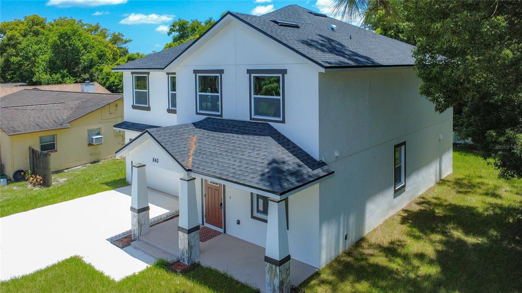 An aerial view of a two-story white house with a dark shingled roof and porch — 840 N TRIPLET LAKE DRIVE, CASSELBERRY, FL