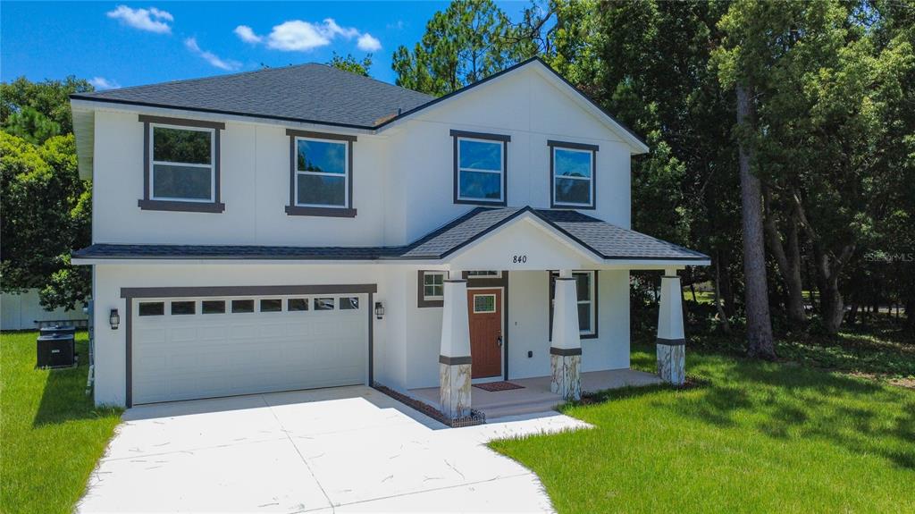 A two-story white house with a two-car garage and a covered front porch — 840 N TRIPLET LAKE DRIVE, CASSELBERRY, FL