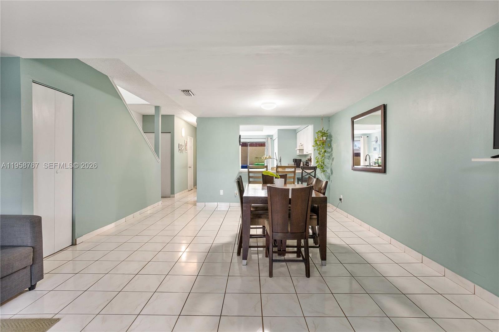A dining area with a wooden table and chairs sits on white tiled floors — 4713 N Pine Island Rd, Sunrise FL 33351, SUNRISE, FL
