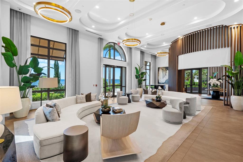 A modern living room features a beige sofa, two armchairs, and floor-to-ceiling windows with views — 2103 BAYSHORE BOULEVARD UNIT 703, TAMPA, FL
