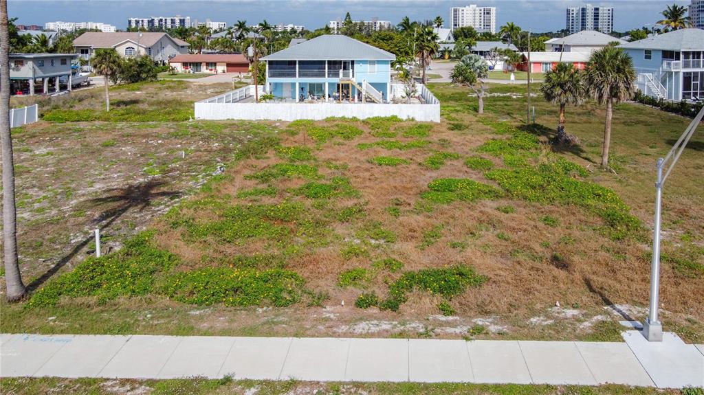 An aerial view of a vacant, grassy residential lot with a sidewalk in the foreground — 8033 ESTERO BOULEVARD, FORT MYERS BEACH, FL