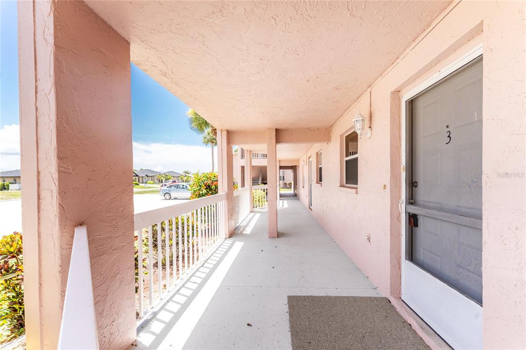 A covered outdoor walkway leads to the entrance of a unit marked with the number three — 179 BOUNDARY BOULEVARD UNIT 3, ROTONDA WEST, FL