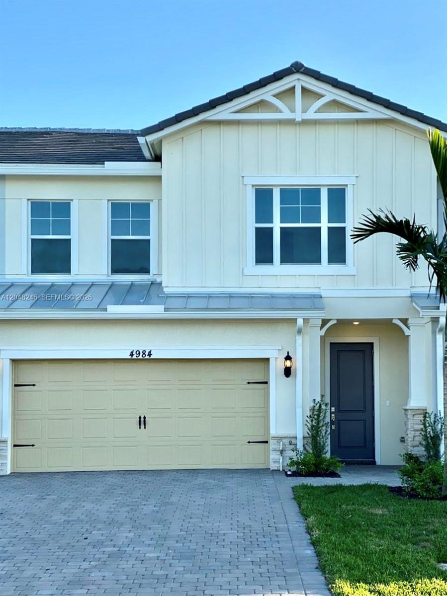 A two-story house exterior features a beige garage, a dark front door, and light siding — 4984 Greenway Dr, Hollywood FL 33021, HOLLYWOOD, FL