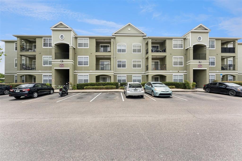 A three-story apartment building with a parking lot in front — 8136 CLAIRE ANN DRIVE UNIT 207, ORLANDO, FL