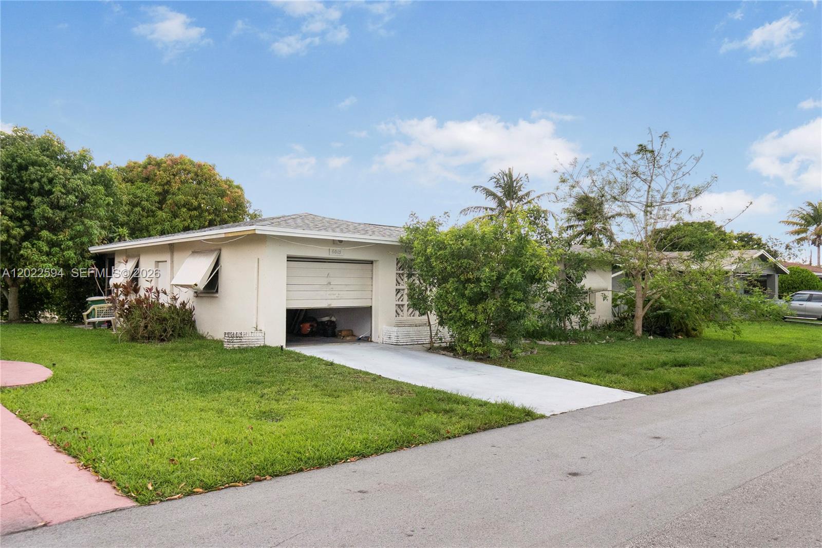 A single-story house with a white exterior, a one-car garage, and a grassy front yard — 6013 NW 68th, Tamarac FL 33321, TAMARAC, FL