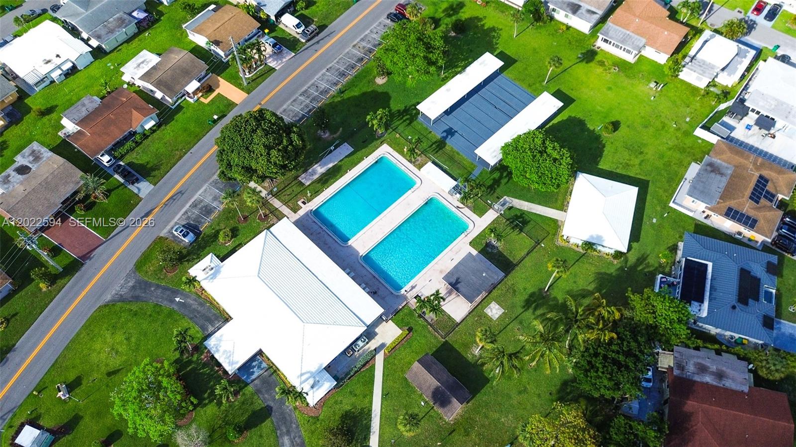 An aerial view shows a community center with two swimming pools and surrounding residential houses — 6013 NW 68th, Tamarac FL 33321, TAMARAC, FL