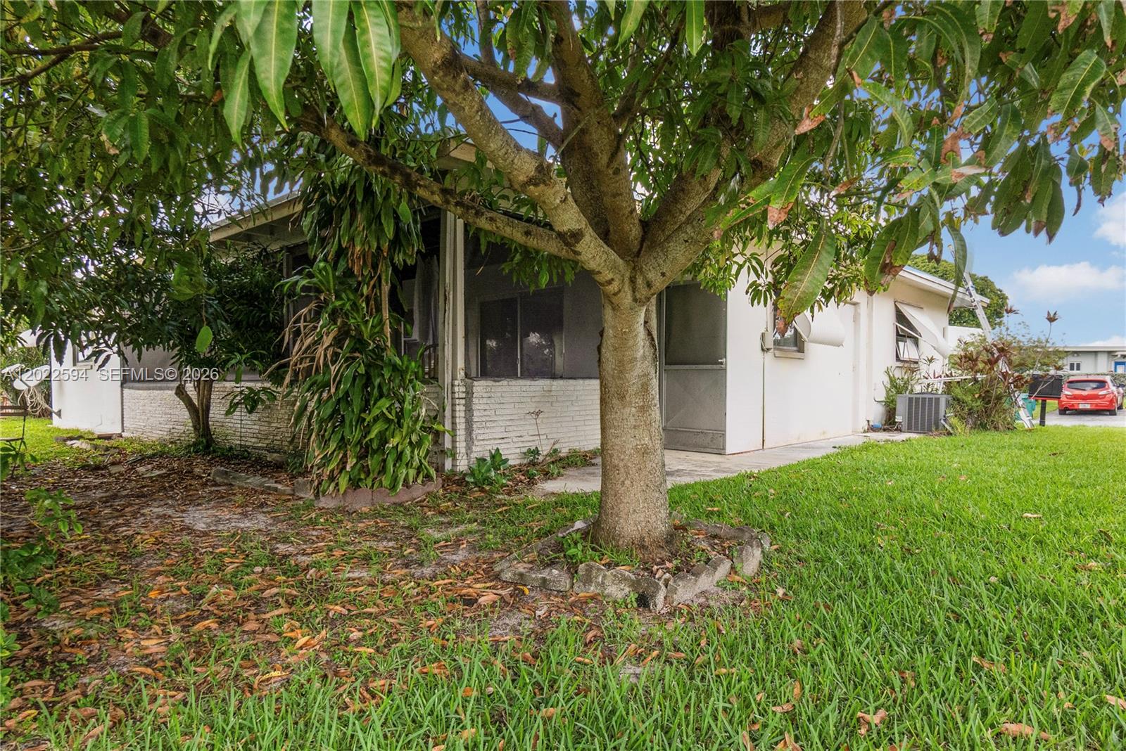 A single-story house with a screened porch and a large tree in the front yard — 6013 NW 68th, Tamarac FL 33321, TAMARAC, FL