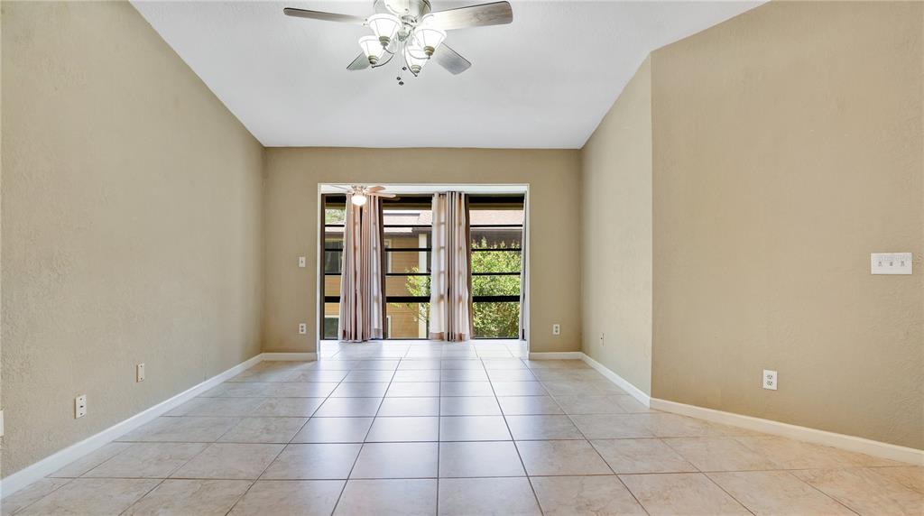 A tiled dining area features a ceiling fan and sliding glass doors leading to a balcony — 6019 SCOTCHWOOD GLEN UNIT 204, ORLANDO, FL
